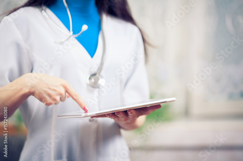 Doctor working on a digital tablet with copy space