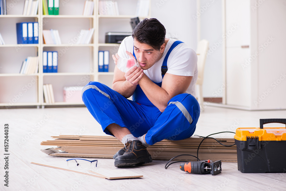Young worker working on floor laminate tiles Young worker working on floor laminate tiles