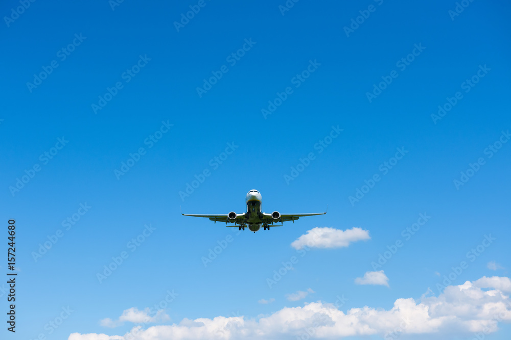 Airplane in blue sky front view from ground Airplane in blue sky front view from ground
