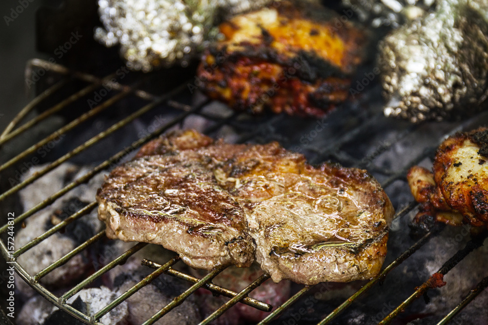 Tasty fresh appetizing meat beef on grill cooking on open fire on grill grid. Nature Background. Closeup.