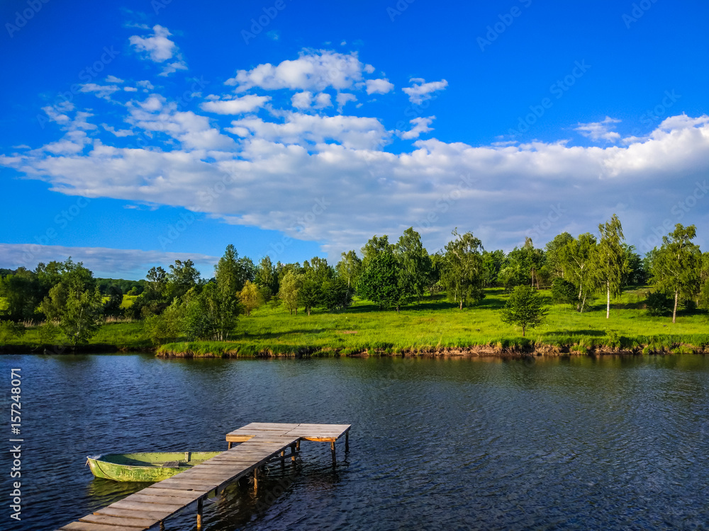 Fototapeta premium Background of nature landscape with clouds and lake with boat