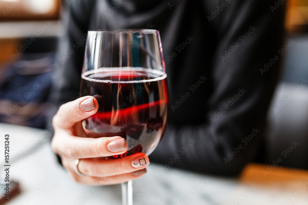 Unrecognisable Woman holding a wine glass in restaurant, alcohol concept