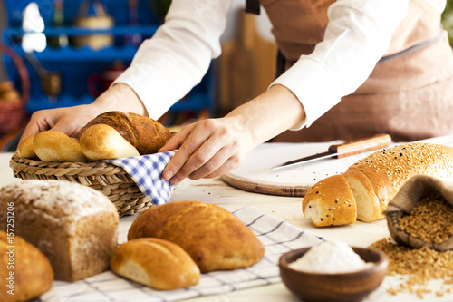 Female hands holding freshly bread in basket