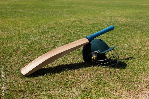 High angle view of cricket bat and helmet on field