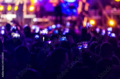 Hand with a smartphone records live music festival