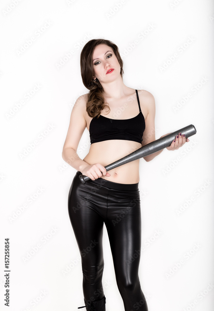 young pretty woman in leather pants and black top holds grey baseball bat young pretty woman in leather pants and black top holds grey baseball bat
