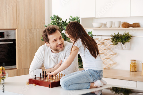 Father admiring his daughter during chess game
