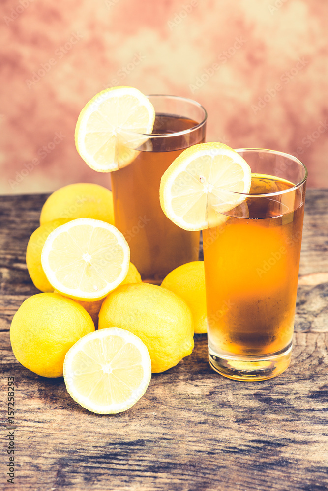 lemon ice tea on wooden table with lemons around lemon ice tea on wooden table with lemons around