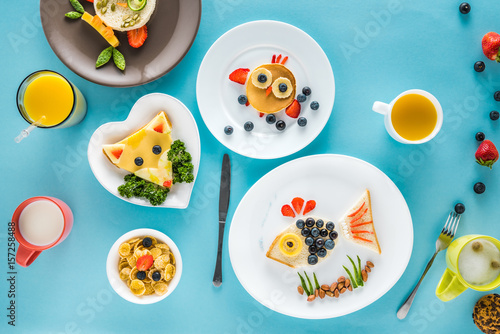 top view of food styling breakfast with various dishes on blue background
