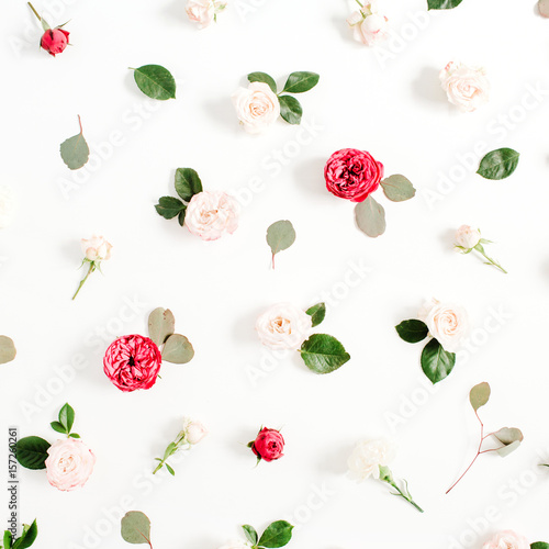 Fototapeta Naklejka Na Ścianę i Meble -  Floral pattern made of red and beige roses, green leaves, branches on white background. Flat lay, top view. Valentine's background. Pattern of flowers. Texture