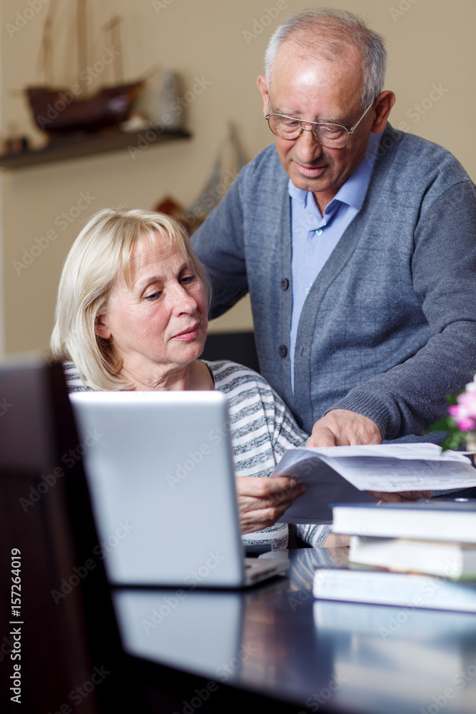 Senior couple checking their bills at home Senior couple checking their bills at home