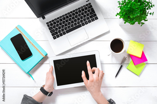 Hand use white tablet on desk table top view