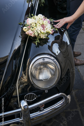 Wedding Flower bouquet, shoes, hand with ring leaning on a car