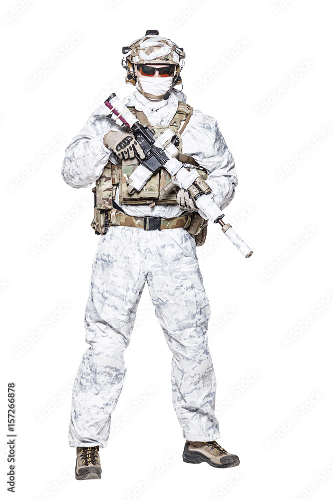 Special forces operator of Navy Seals armed with assault rifle with closed face in polarized sunglasses and military winter camo clothes designed to operations in extreme conditions. Studio shot Special forces operator of Navy Seals armed with assault rifle with closed face in polarized sunglasses and military winter camo clothes designed to operations in extreme conditions. Studio shot