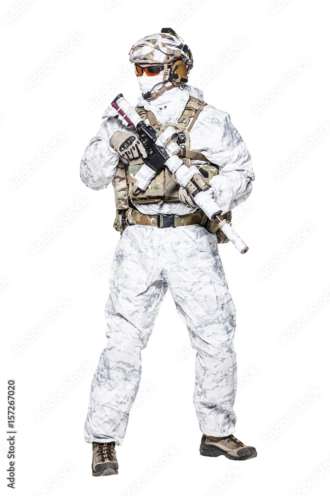 Special forces operator of Navy Seals armed with assault rifle with closed face in polarized sunglasses and military winter camo clothes designed to operations in extreme conditions. Studio shot Special forces operator of Navy Seals armed with assault rifle with closed face in polarized sunglasses and military winter camo clothes designed to operations in extreme conditions. Studio shot
