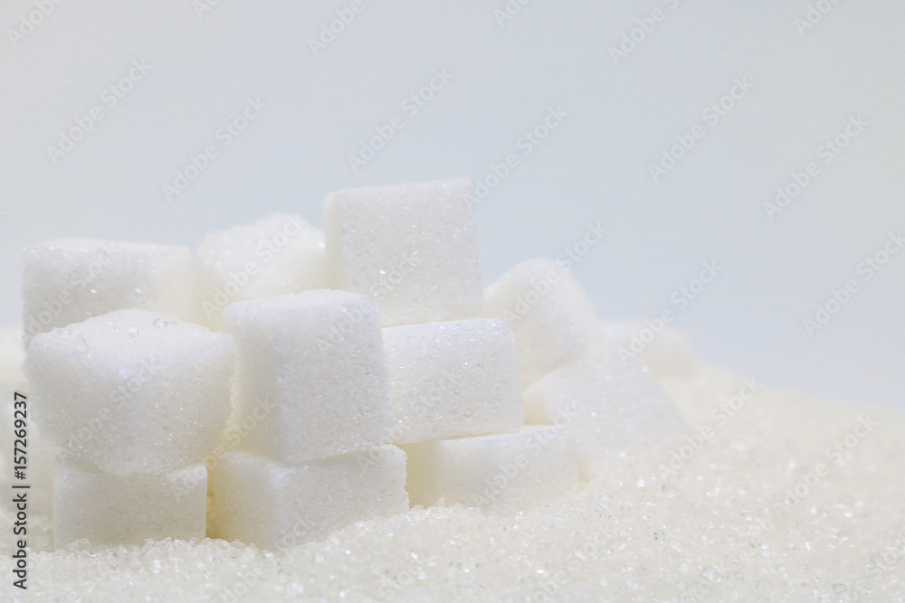 Pure refined sugar and sugar cubes. Sweet food ingredient, the diet health risks related to diabetes and calorie intake. Pure refined sugar and sugar cubes. Sweet food ingredient, the diet health risks related to diabetes and calorie intake.