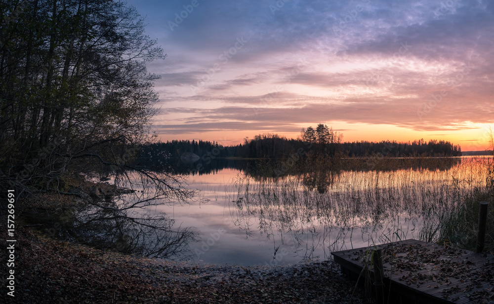 Scenic landscape with sunset and lake at autumn
