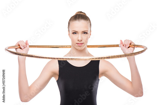 attractive rhythmic gymnast in bodysuit posing with hoop and looking at camera isolated on white