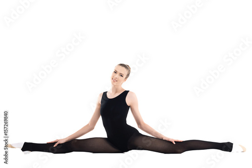 Athletic young woman in sportswear stretching and smiling at camera