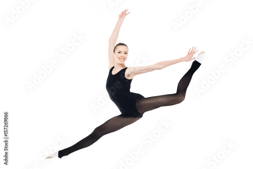 Smiling young sportswoman exercising rhythmic gymnastics isolated on white