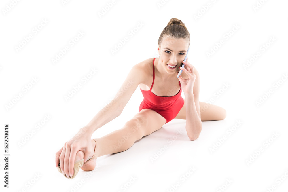 Fototapeta premium smiling rhythmic gymnast talking on digital smartphone isolated on white