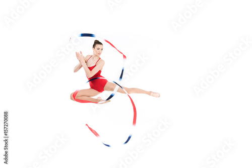 young caucasian woman rhythmic gymnast jumping with colorful rope
