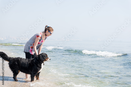 Happy woman playing with dog on beach