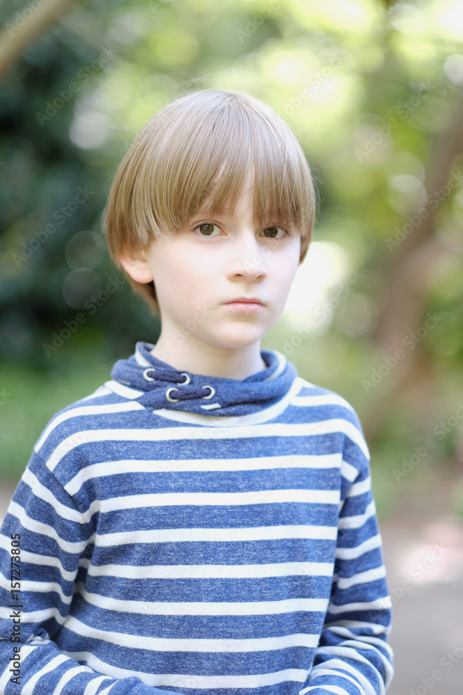 Portrait of a schoolboy in a striped sweater in the park Portrait of a schoolboy in a striped sweater in the park