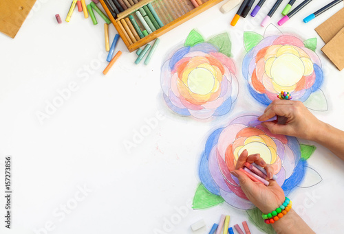 Flowers drawn art with pastels. Pencil, markers and hands of the artist on a white background. photo