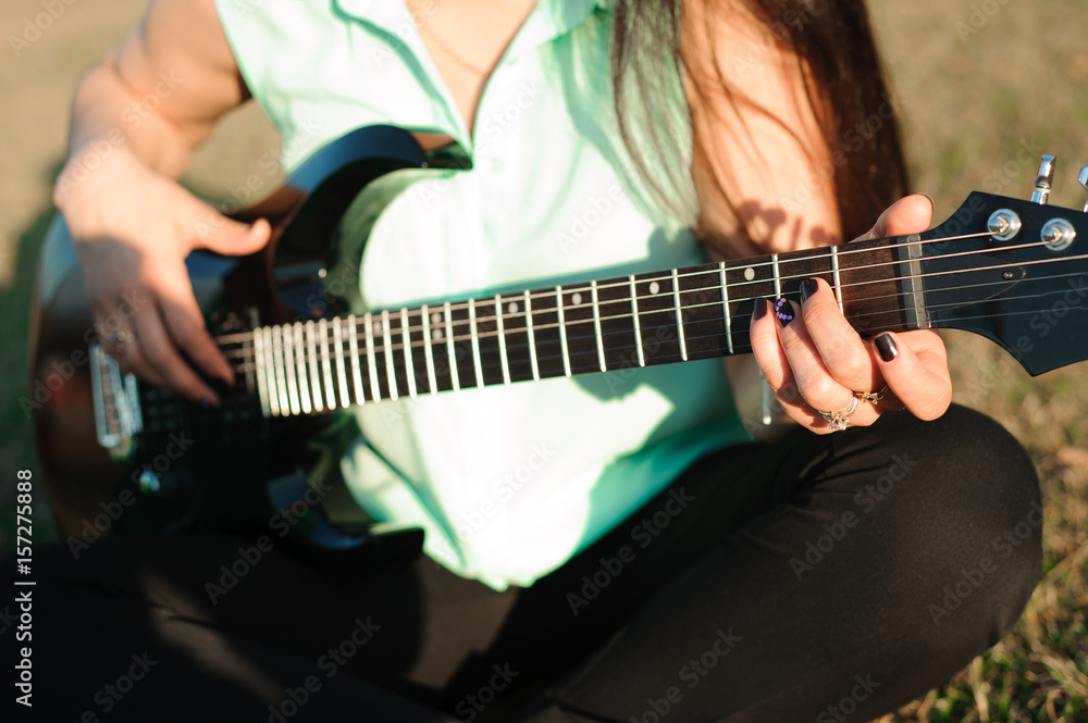 Romantic young couple portrait playing guitar under blue sky.