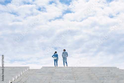 A couple stand high on top of some steps