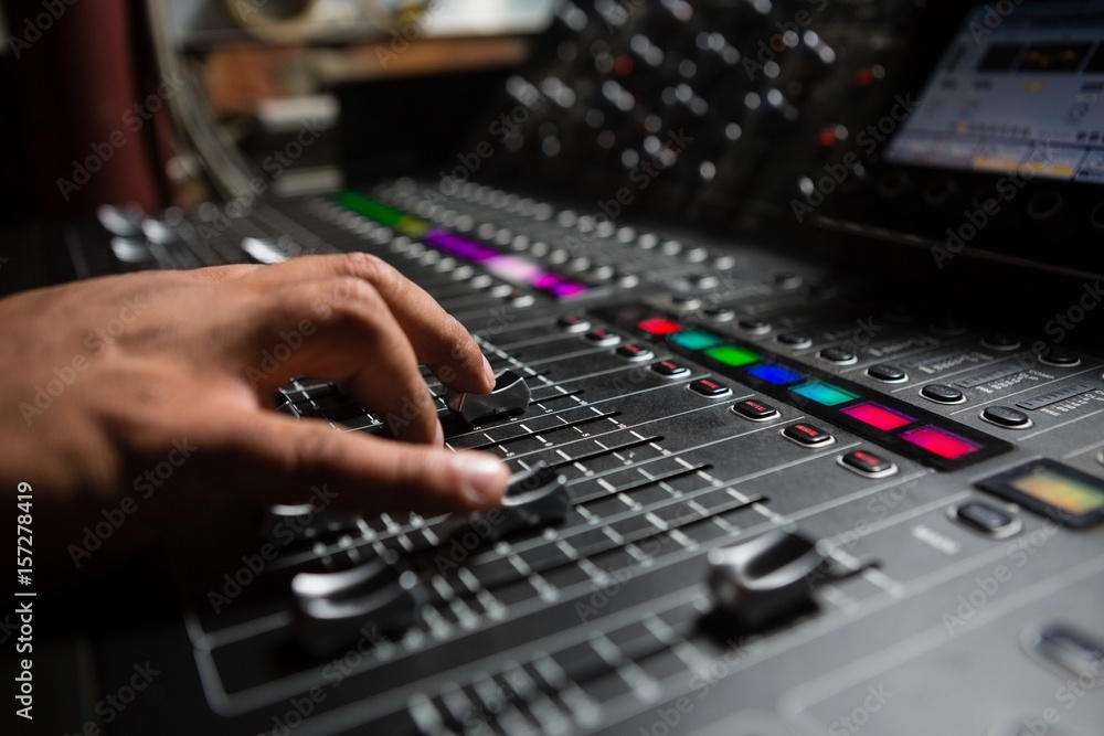 Hand of male audio engineer using sound mixer Hand of male audio engineer using sound mixer