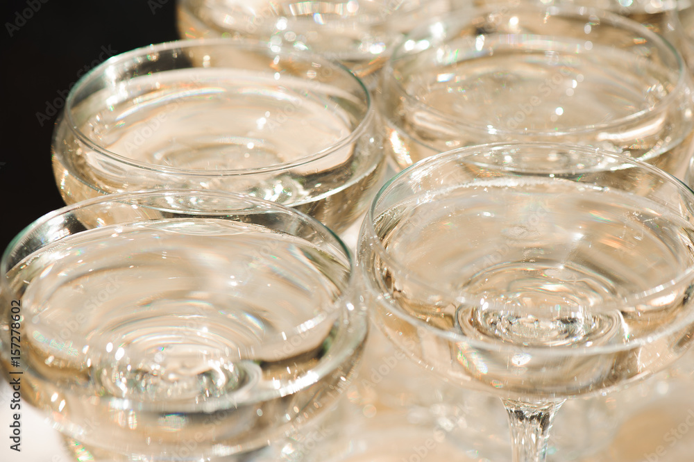 A lot of wine glasses with a cool delicious champagne or white wine at the bar. Alcohol background.