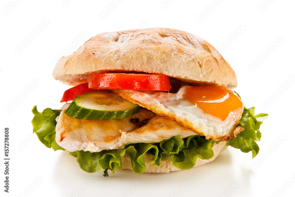 Sandwich with fried egg and chicken fillet on white background