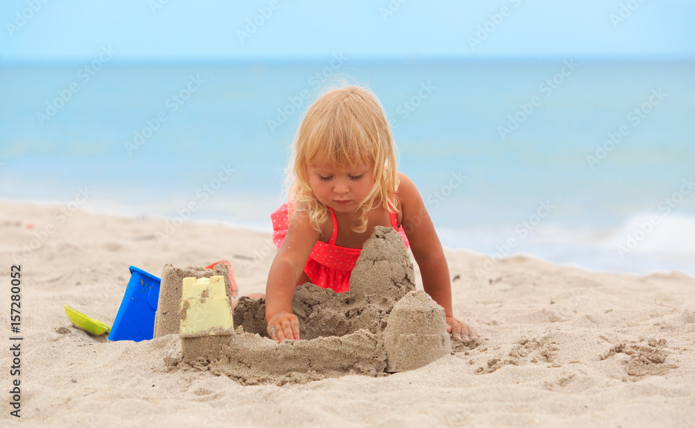 cute little girl play with sand on beach cute little girl play with sand on beach