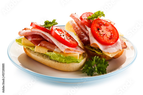 Sandwiches with meat, cheese and vegetables on white background