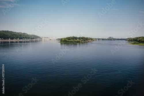 Broad river runs along green shore