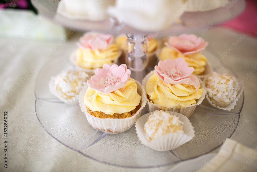 Cupcakes with yellow cream and pink flowers Cupcakes with yellow cream and pink flowers