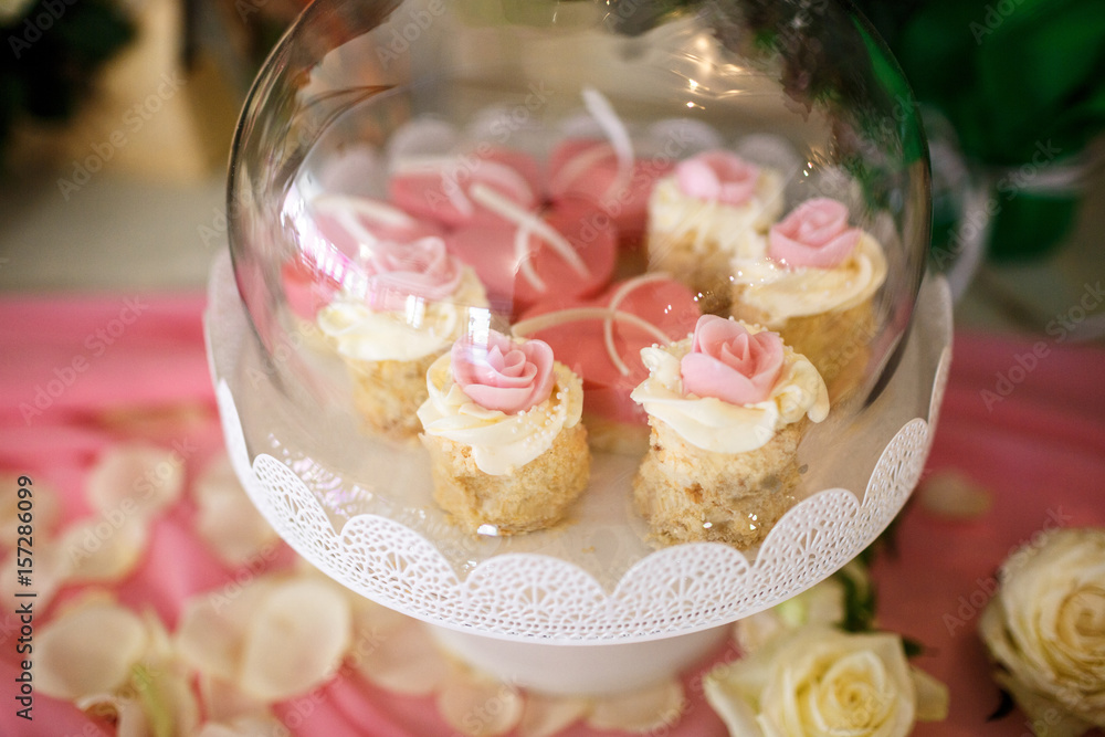 Cupcakes with yellow cream and pink flowers Cupcakes with yellow cream and pink flowers