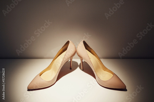 Beige shoes for a birde stand on the dressing table