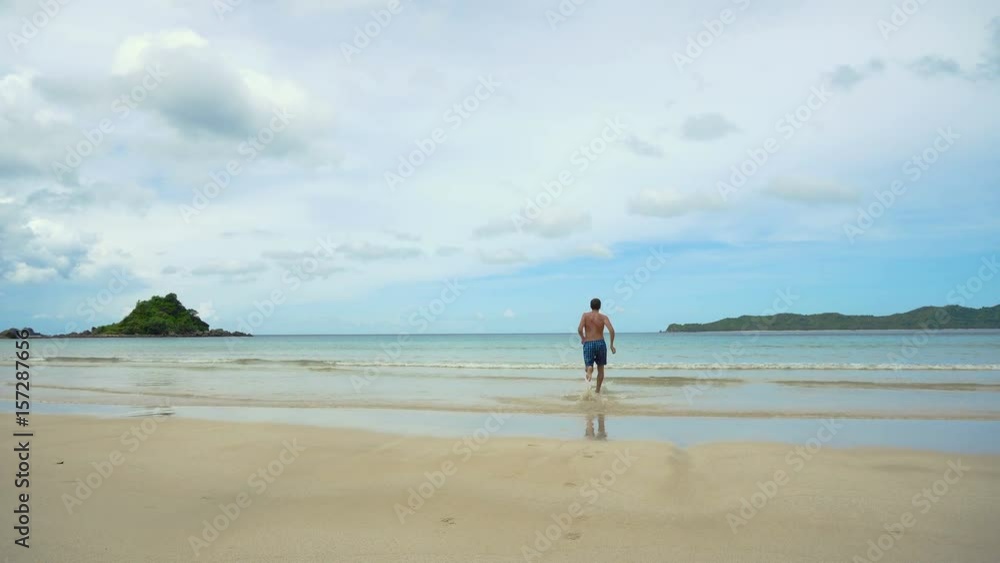 Man running along beach. Fitness sports runner man jogging on beach. Handsome young fit sporty male athlete running outside on beautiful beach training. 4K video. Man running along beach. Fitness sports runner man jogging on beach. Handsome young fit sporty male athlete running outside on beautiful beach training. 4K video.