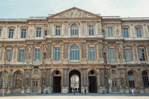 People walk under the archs of Louvre museum