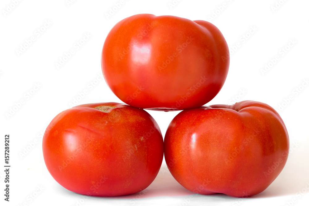 Three red tomatoes in a pile isolated on white background Three red tomatoes in a pile isolated on white background