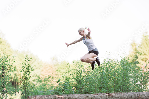 Woman jumping on wood chunks