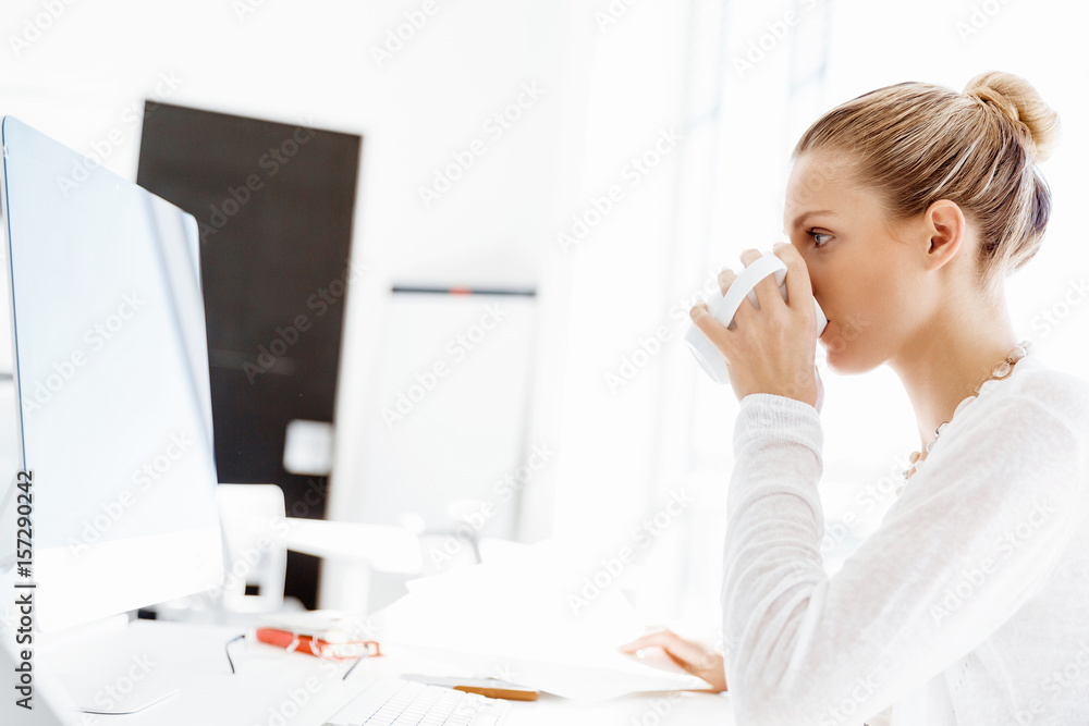 Attractive office worker sitting at desk Attractive office worker sitting at desk