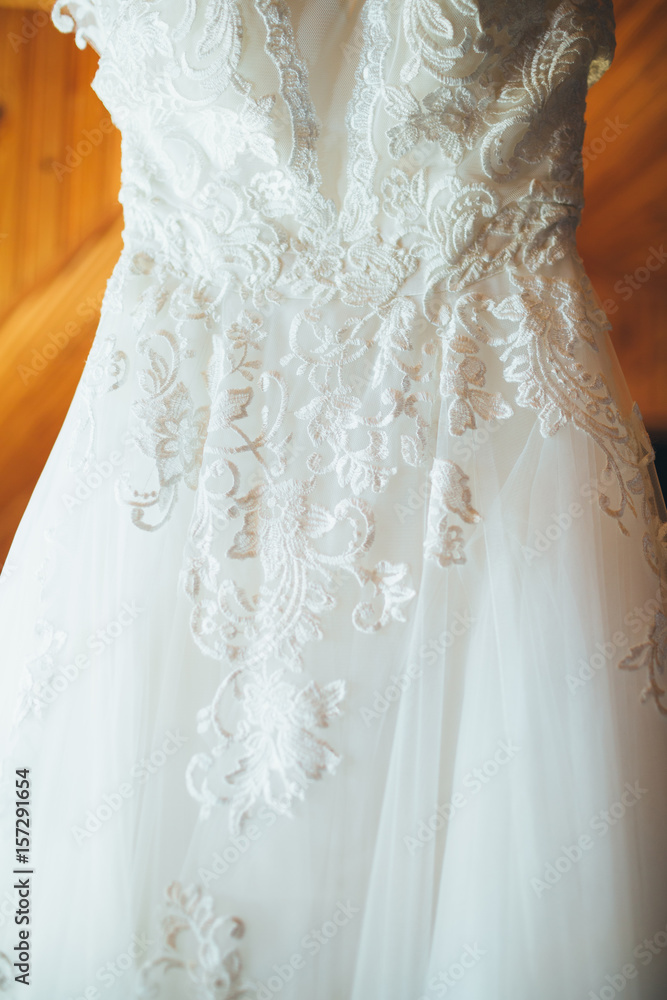 The wedding dress hands on the hanger in the room The wedding dress hands on the hanger in the room