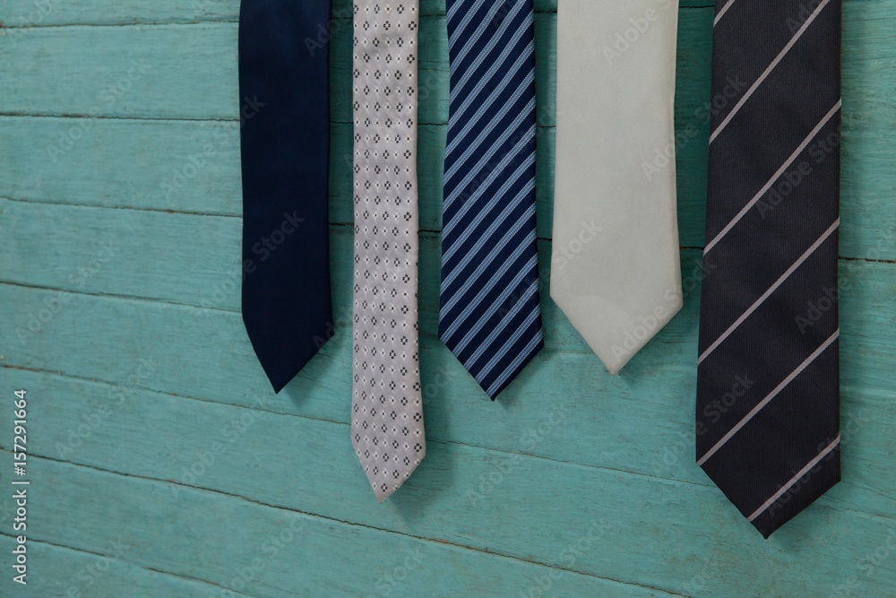 Close up of various neckties hanging by green wall Close up of various neckties hanging by green wall