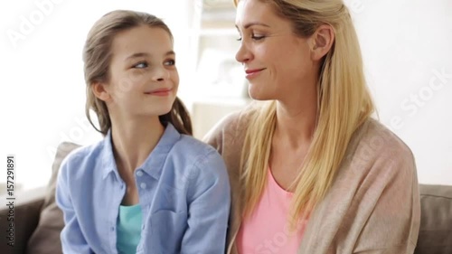mother and girl turning to each other at home