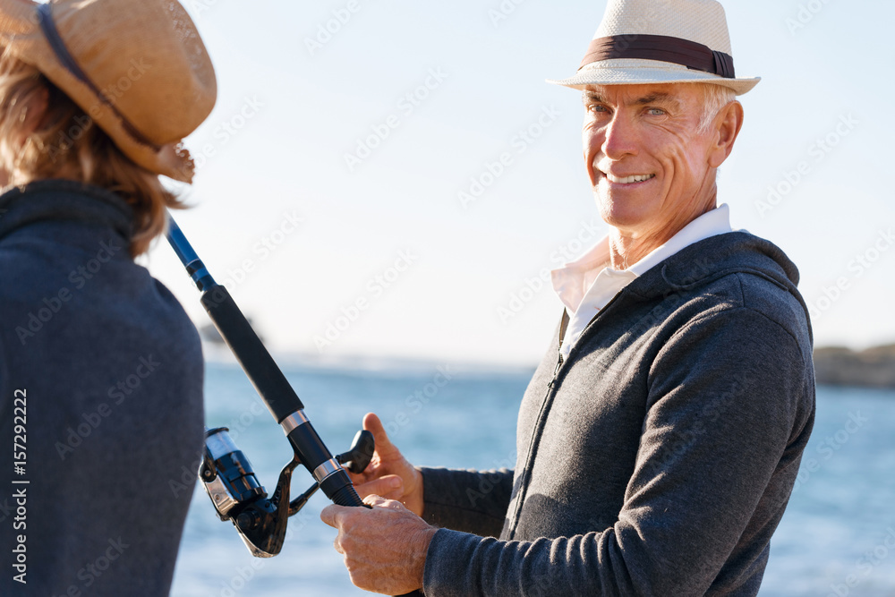 Obraz premium Senior man fishing with his grandson