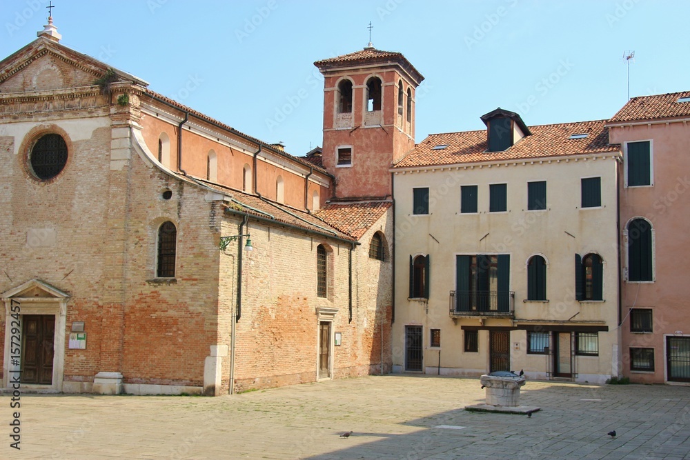 Quiet square with church and well in the district San Polo in Venice, Italy, Europe.